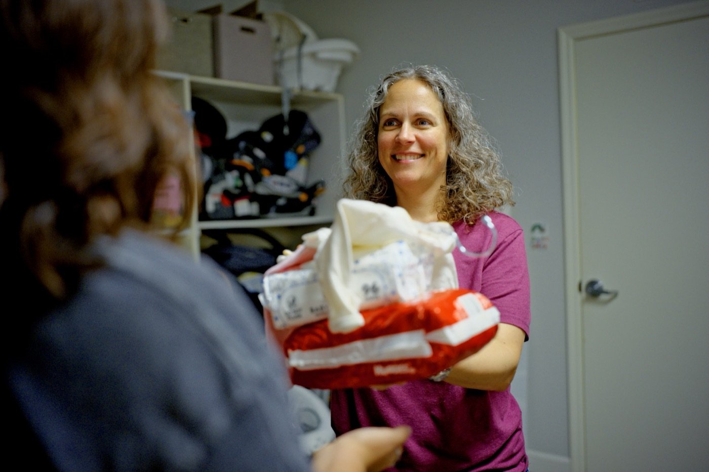 A Hope Resource Center volunteer handing baby supplies to a mom